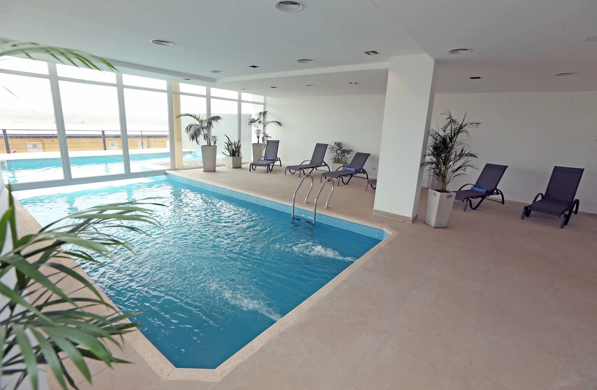Piscina climatizada con vista panorámica y área de relax en Wenelen Suites, una propuesta de alojamiento con amenities de nivel hotelero en Vaca Muerta.