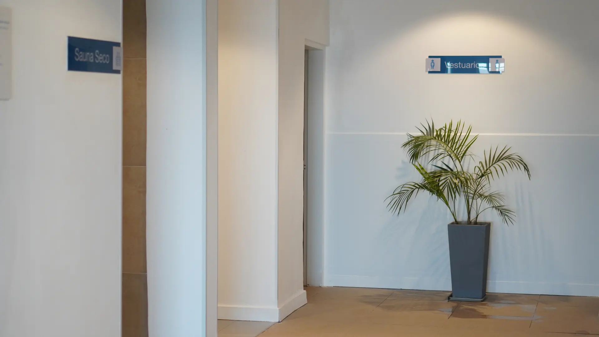 Área de acceso a vestuarios y sauna en Wenelen Suites, con señalética clara y diseño funcional, parte del circuito de wellness del complejo.